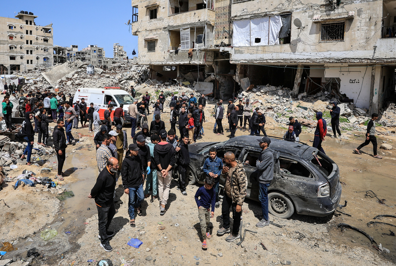 Palestinians inspect the damage after a person was hit by an Israeli strike in Gaza City, Monday. (Reuters-Yonhap)