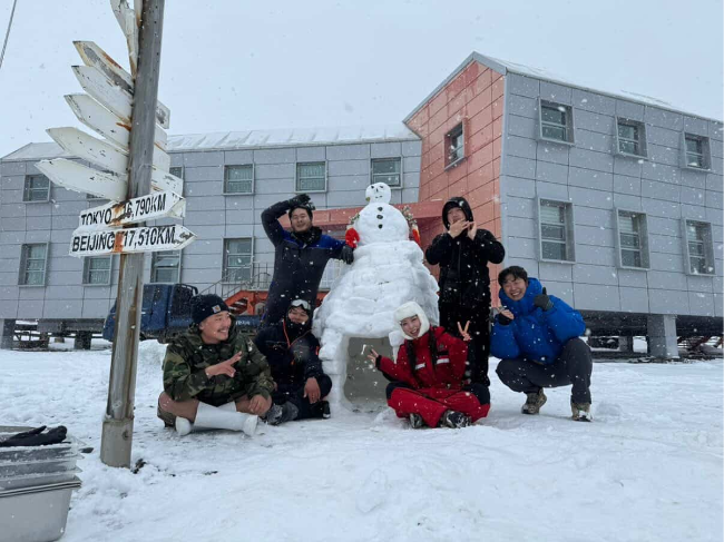 Kim Hee-soo and researchers at the King Sejong Station pose for a photo after making a snowman and igloo. (Kim Hee-soo)