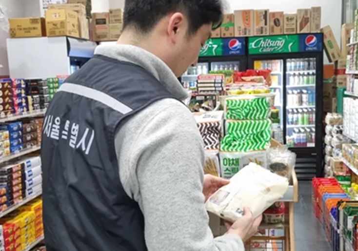 A food safety inspector from the Seoul Metropolitan Government inspects low-cost packaged pastries at a subway station convenience store in March. (Seoul Metropolitan Government)