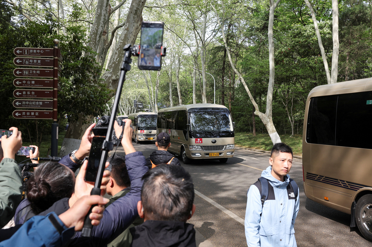 People take pictures of the motorcade of Cheng Li-wun, chairperson of Taiwan's opposition party, Kuomintang , on the day she visits Sun Yat-sen Mausoleum in Nanjing, China, Wednesday. (Reuters-Yonhap)