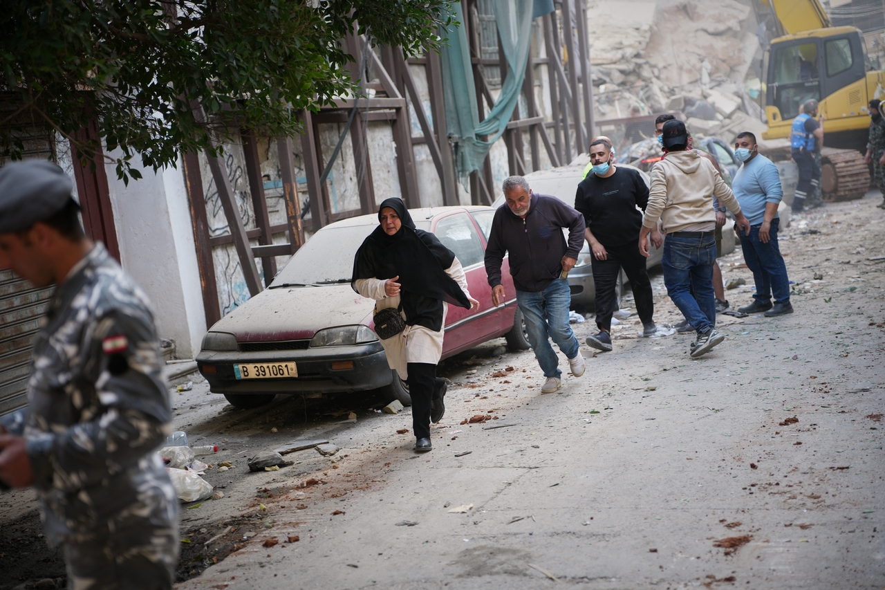 People rush away from the site of an Israeli airstrike in Beirut on Wednesday (local time). (AP)