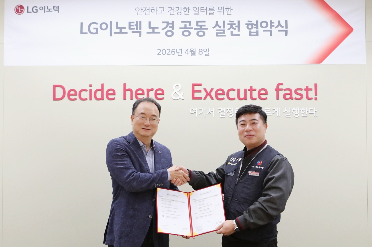 Moon hyuk-soo (left), CEO of LG Innotek, and Lee  Joong-il, chairman of the union, pose for a photo after a joint labor-management action agreement ceremony on Wednesday at the LG Innotek Magok headquarters in Seoul. (LG Innotek)