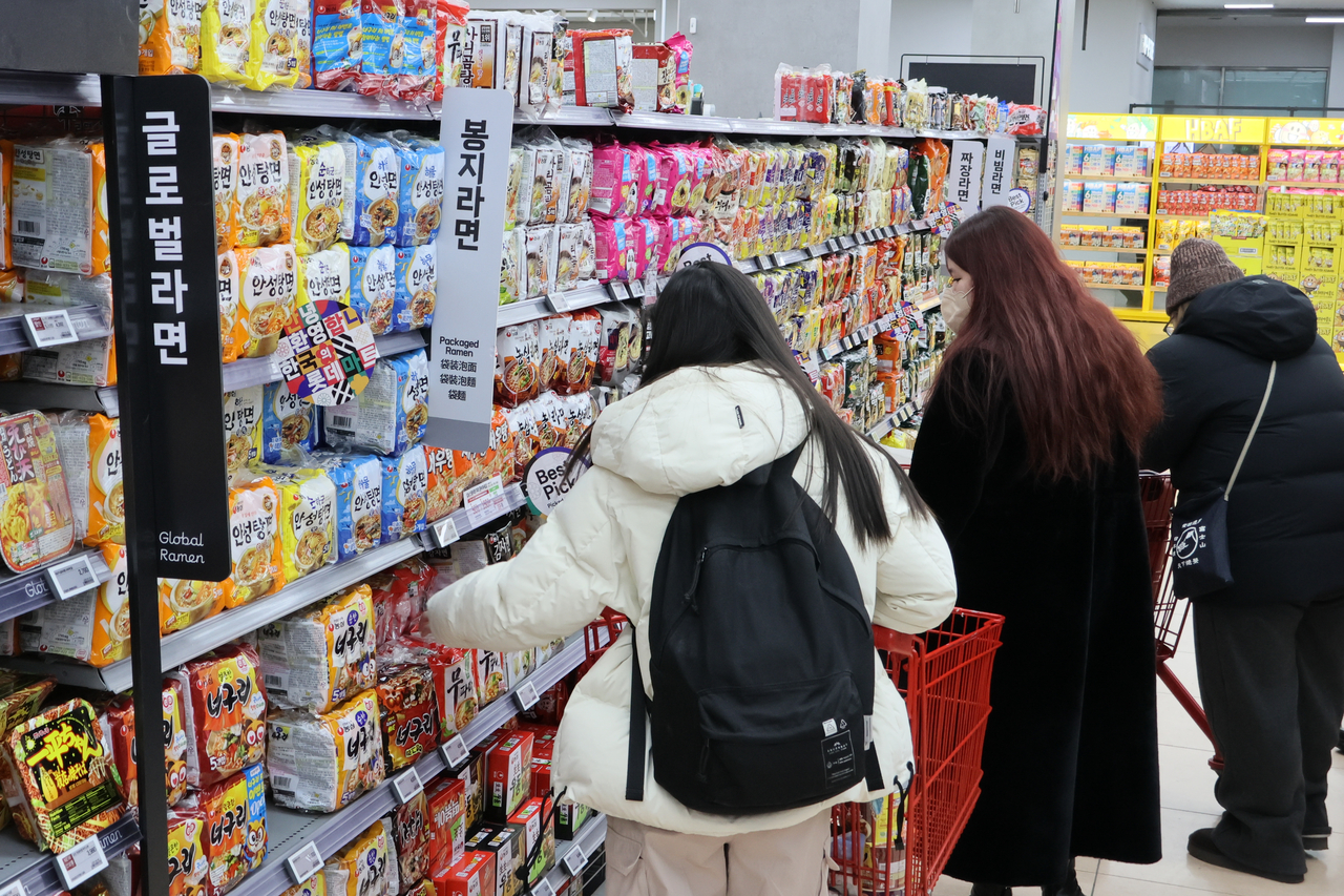 Foreigners shop for instant noodle products at a supermarket in Seoul on Jan. 12. (Yonhap)