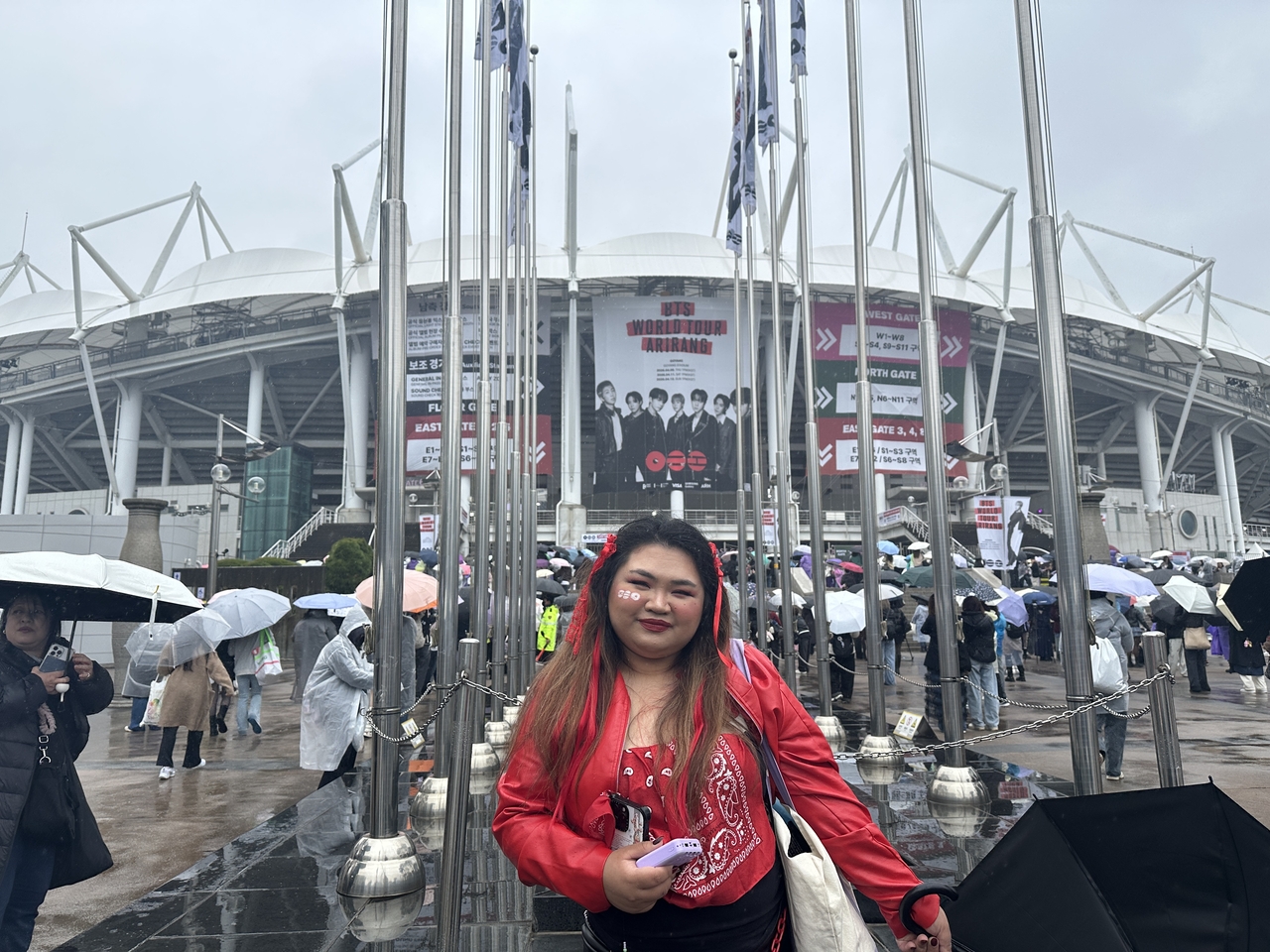 Tricia Shane, a BTS fan from the US, poses in front of Goyang Stadium, the venue for BTS’ 'Arirang' world tour, on Thursday, wearing red, a key color of the group’s latest album. (Lee Jung-joo/The Korea Herald)