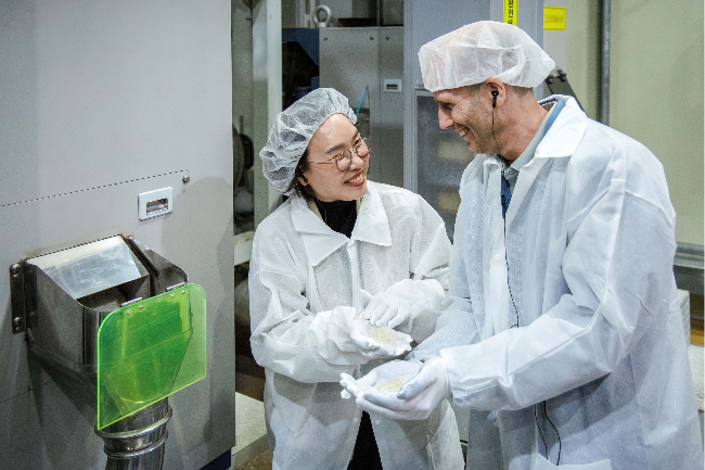 Coupang Harold Rogers talks to a worker at a grain processing facility. (Coupang)