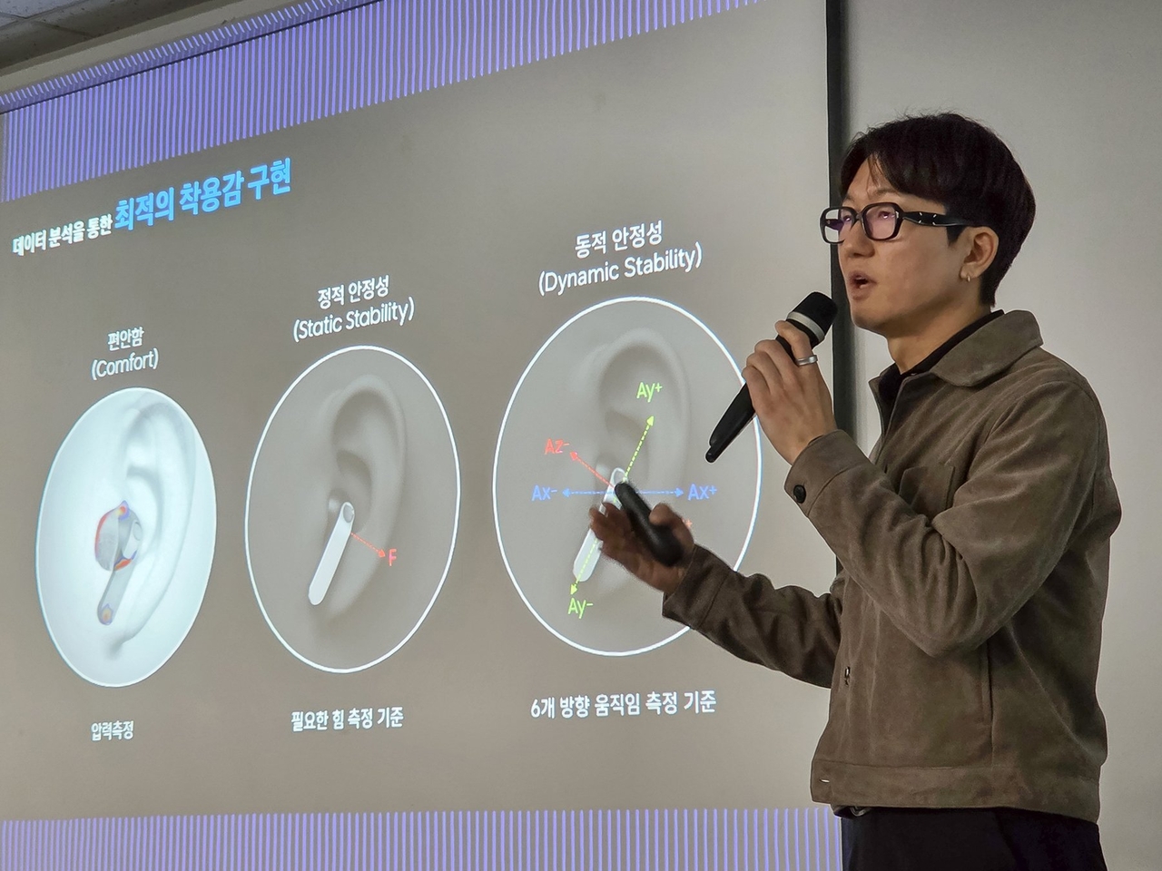 Song Jun-yong, a design group leader at Samsung's MX division, explains the three-axis fit methodology used to develop the Galaxy Buds 4, measuring ear pressure for comfort, retention force for static stability and six-directional movement for dynamic stability, during a media briefing in Seoul on Thursday. (Samsung Electronics)