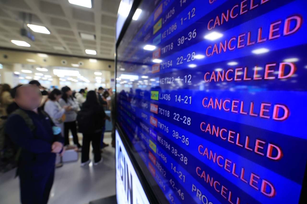 A departure information display board at Jeju International Airport on the southern island shows flight cancellations and delays on Thursday. (Yonhap)