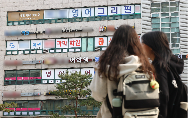 Students stand in front of private academies in Gangnam-gu, Seoul, on March 12. (Newsis)