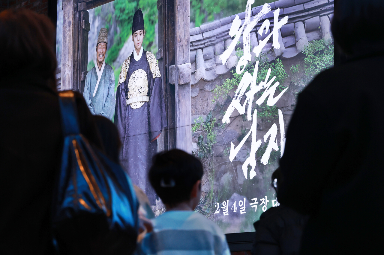 Moviegoers walk by a poster of "The King's Warden" at a cinema in Seoul on March 8. (Yonhap)