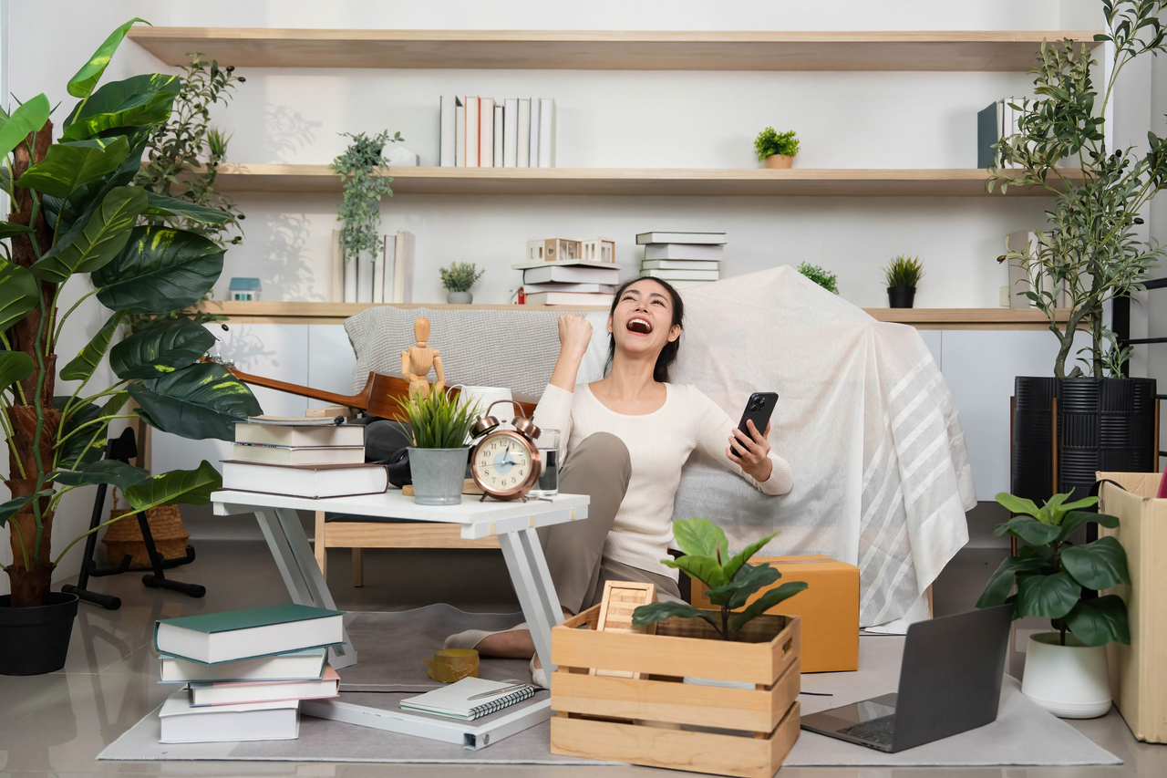 A woman sits among unpacked boxes after moving into a new home. (123rf)