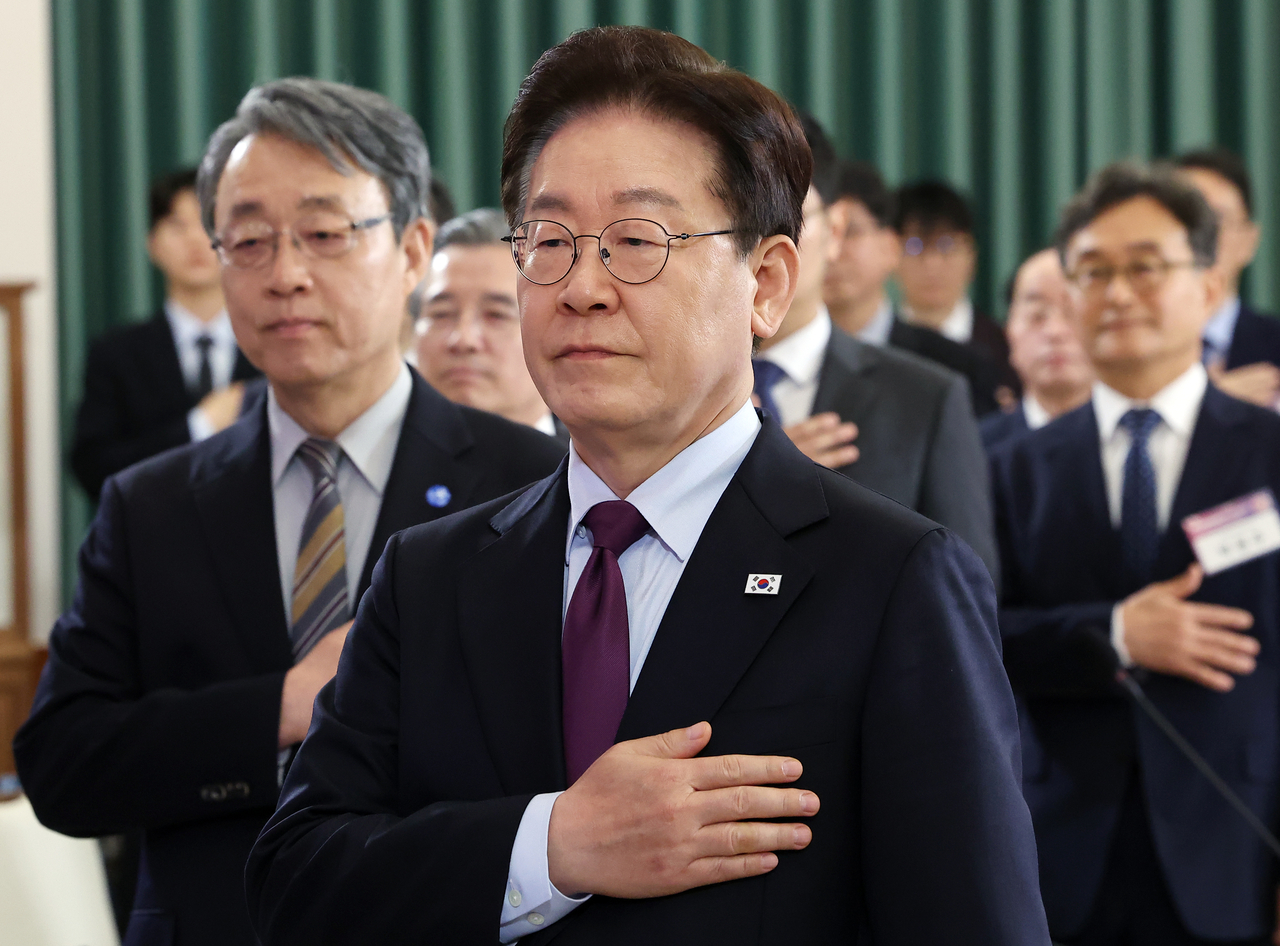 President Lee Jae Myung performs a national salute during the inaugural plenary session of the National Economic Advisory Council at Cheong Wa Dae in Seoul on April 9. (Yonhap)