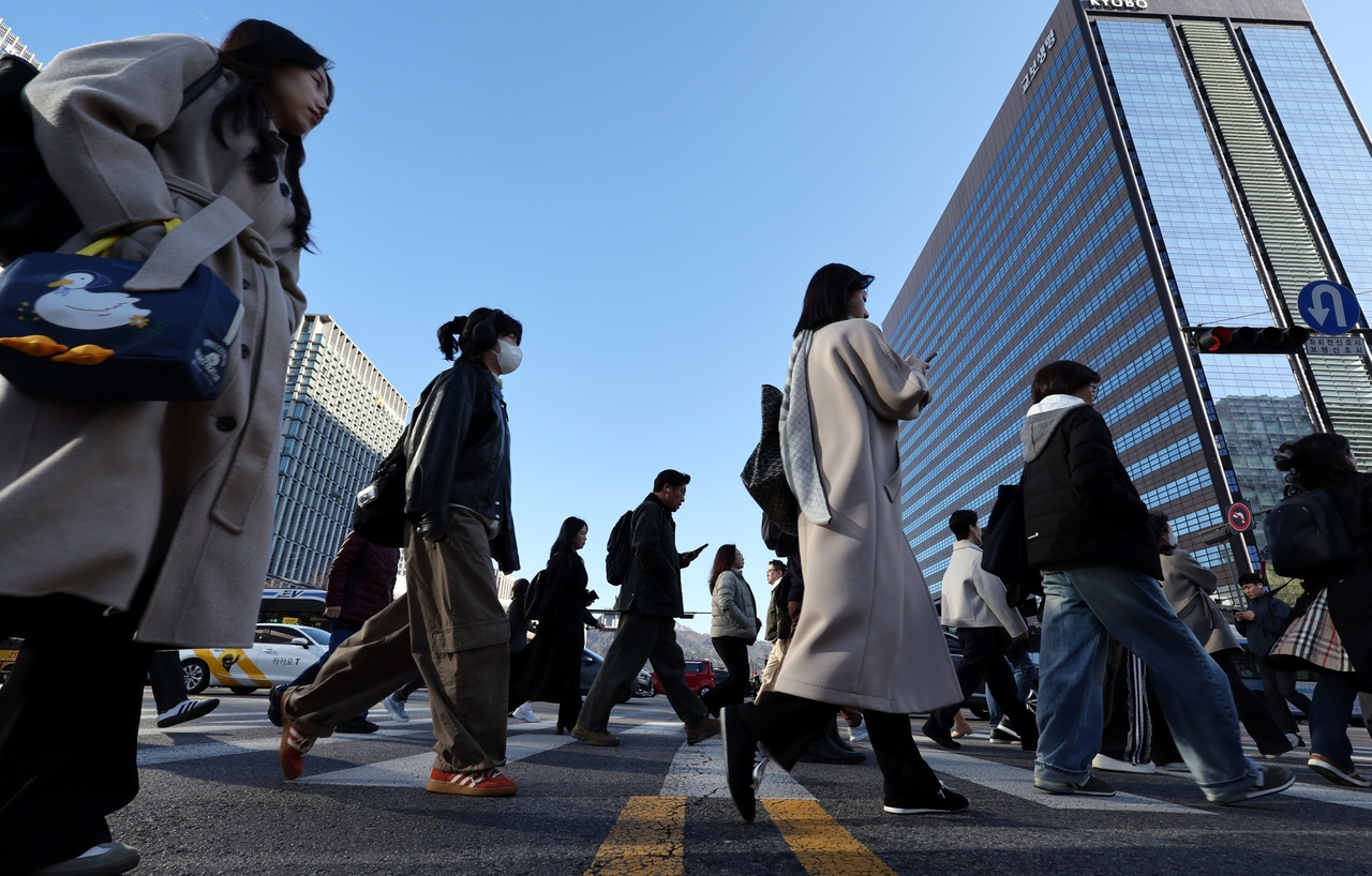 Pedestrians cross a road in central Seoul on Thursday. (Newsis)