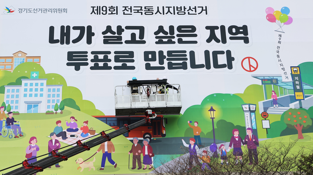 Officials install a banner encouraging voter participation at the Gyeonggi Provincial Election Commission in Suwon, Gyeonggi Province, on April 9,  some 55 days ahead of the June 3 nationwide local elections. (Yonhap)
