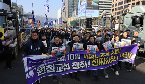 Members of the Korean Confederation of Trade Unions march with placards demanding that contractors negotiate with subcontracted workers at a rally in Seoul on March 10. (Yonhap)