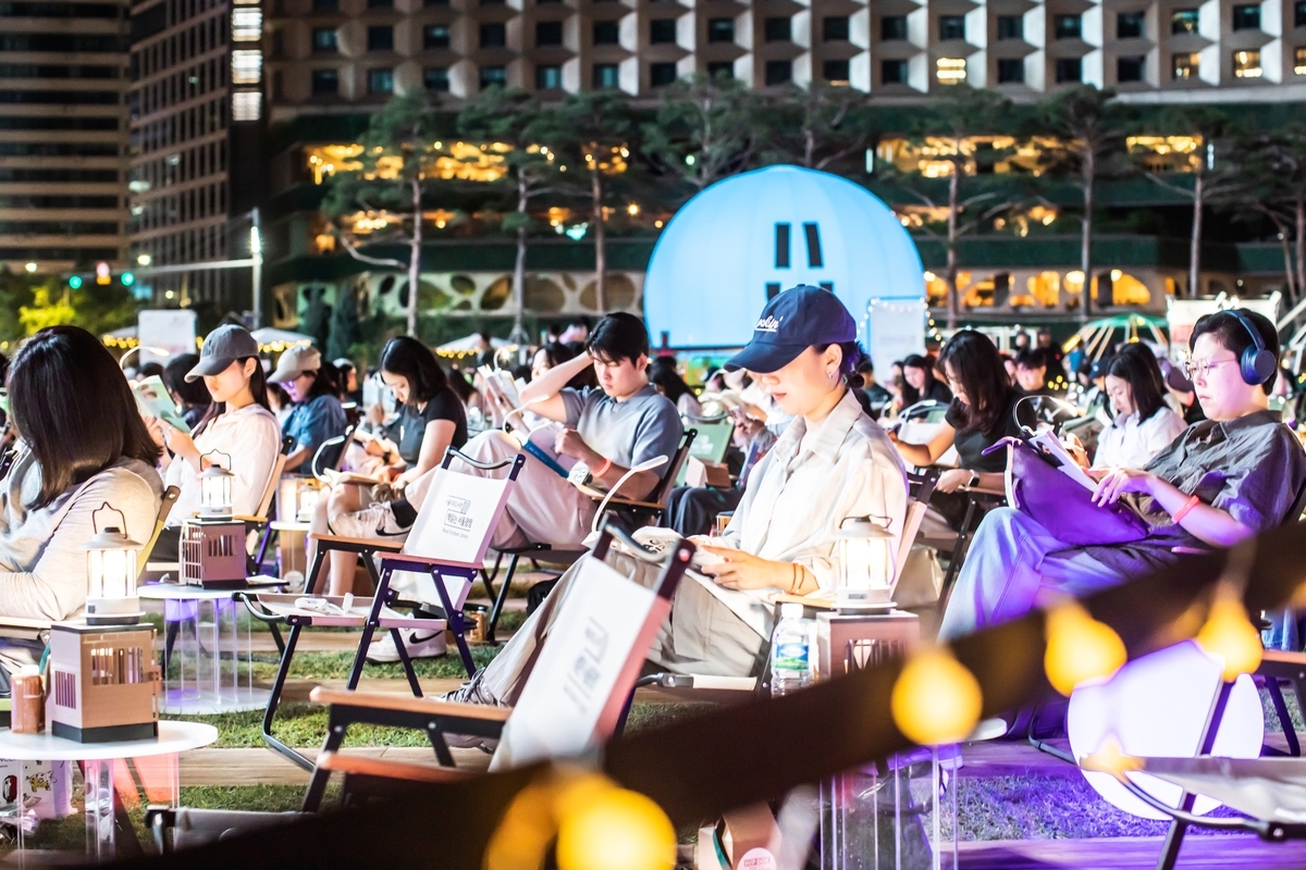 Citizens read books in Seoul Plaza as part of the city's outdoor library program. (Seoul Metropolitan Government)