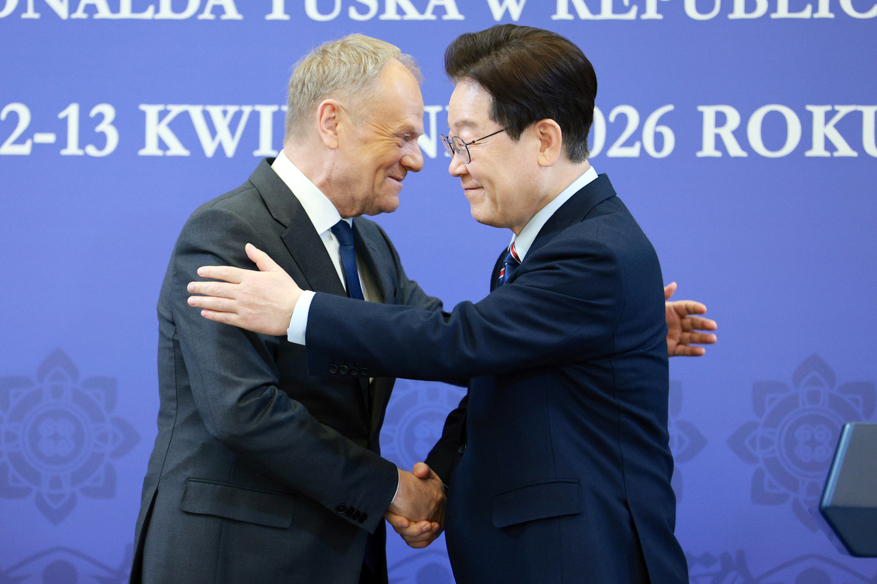 President Lee Jae Myung (right) shakes hands with Polish Prime Minister Donald Tusk after a joint press conference at Cheong Wa Dae in Seoul on Monday. (Yonhap)