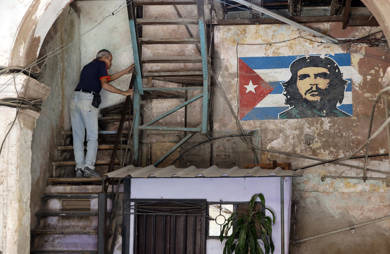 A person climbs a staircase next to a portrait of Ernesto 'Che' Guevara in Havana,  Friday. (EPA-Yonhap)