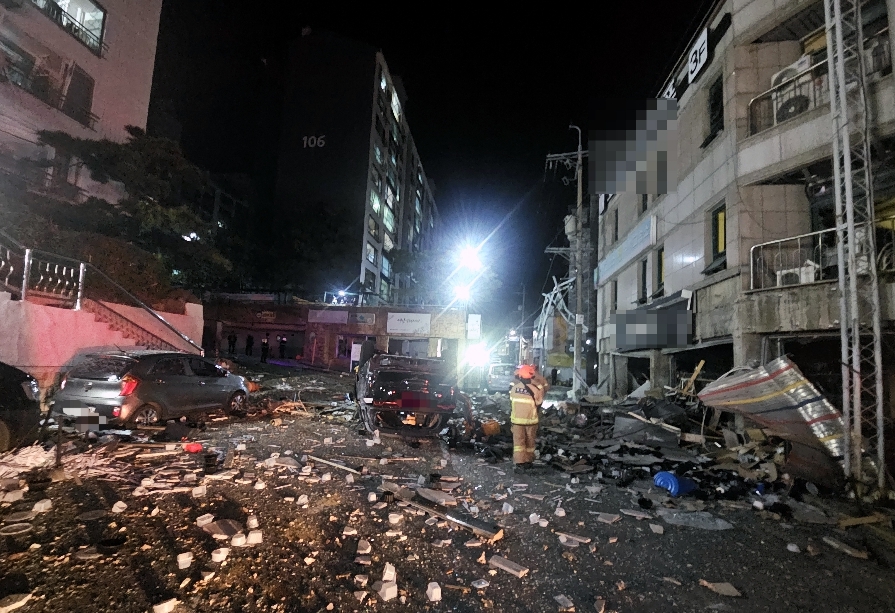 Debris is scattered across a street after an explosion, believed to have been caused by a gas leak, tore through a three-story commercial building in Bongmyeong-dong, Cheongju, around 4 a.m. on Monday. (Yonhap)