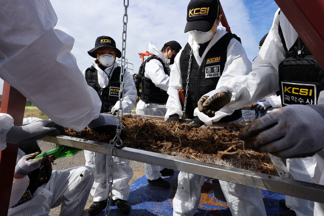 Forensic investigators search for unrecovered human remains at the site of the Jeju Air crash at Muan Airport in South Jeolla Province on Monday. (Yonhap)