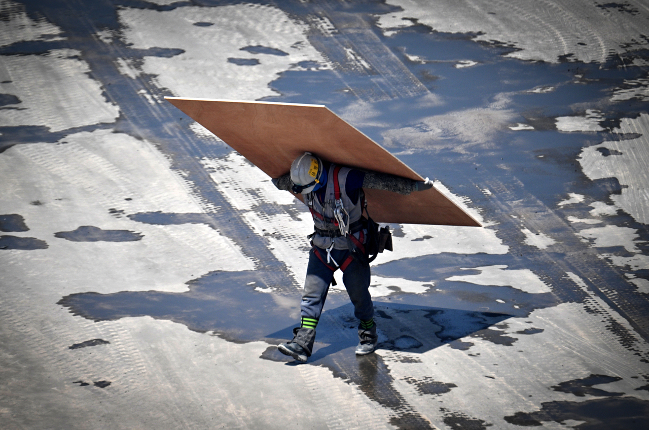 A worker carries construction materials at a site in central Seoul. (Im Se-jun/Herald Business)