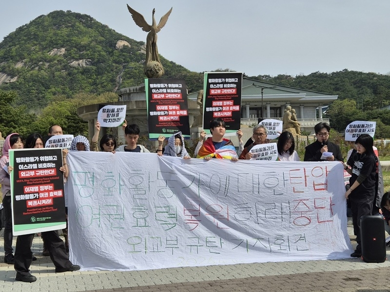 Members of the Thousand Madleens to Gaza hold a protest outside the Cheong Wa Dae on Tuesday, holding a large banner that read, “Stop the crackdown on the peace activist and restore her passport validity." (Yonhap)