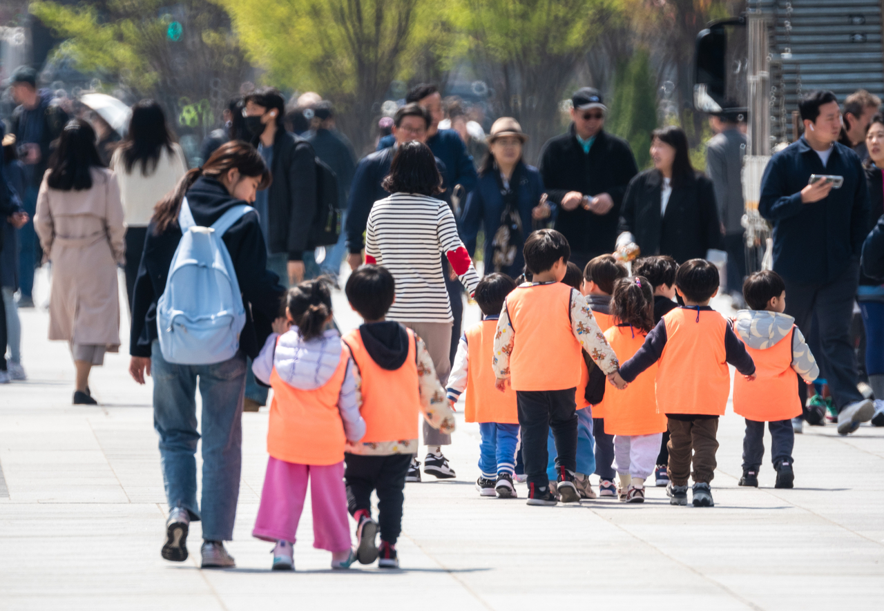 Kindergarten students walk with their teachers in Gwanghwamun Square, central Seoul. (Getty Images)