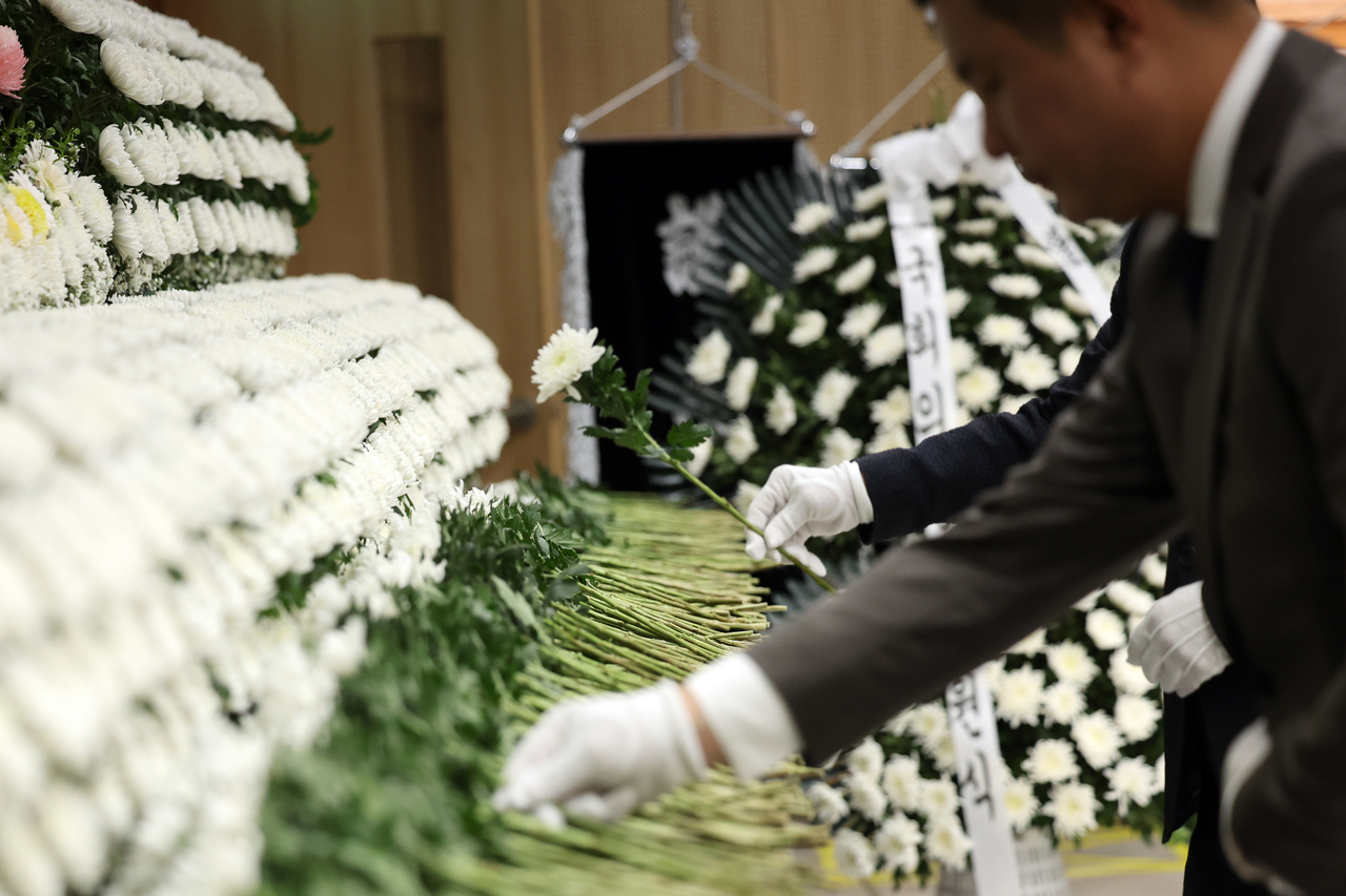 People lay flowers at a funeral home in Wando on Monday to pay their condolences to two firefighters killed in a cold storage warehouse fire. (Yonhap)
