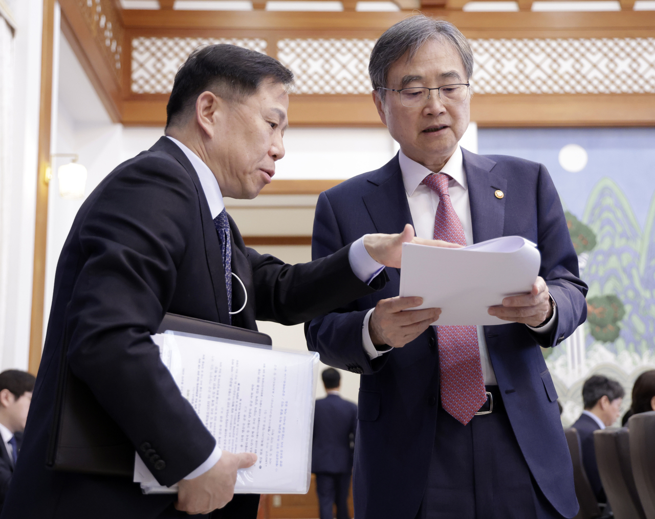 Foreign Minister Cho Hyun (right) speaks with Second Deputy National Security Adviser Lim Woong-soon during a Cabinet meeting and emergency economic review session presided over by President Lee Jae Myung at Cheong Wa Dae in Seoul on Tuesday (Yonhap)
