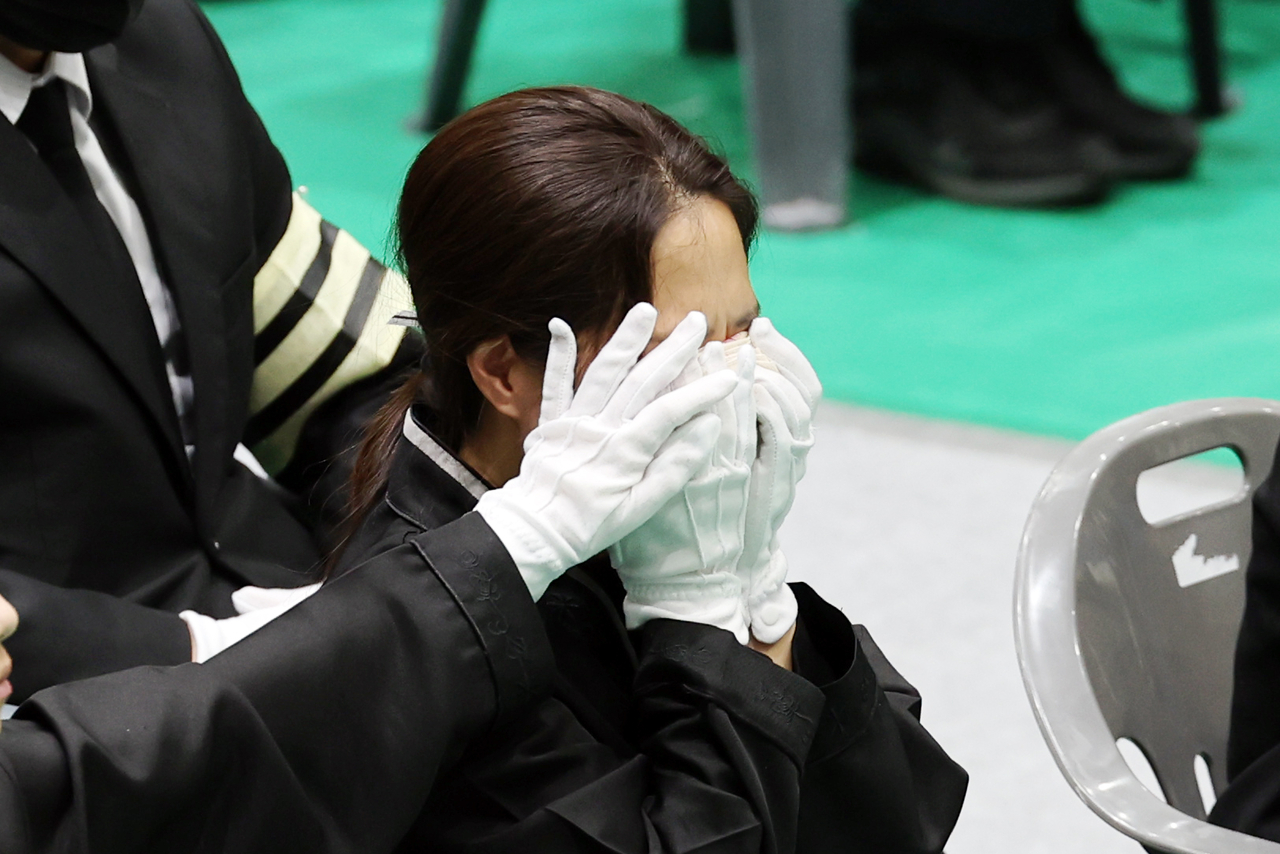 A bereaved family member breaks down in tears during a funeral service for the late Senior Fire Lt. Park Seung-won and Fire Sgt. Noh Tae-young at the Wando Agricultural and Fisheries Cultural and Sports Center in South Jeolla Province on Tuesday morning. (Yonhap)