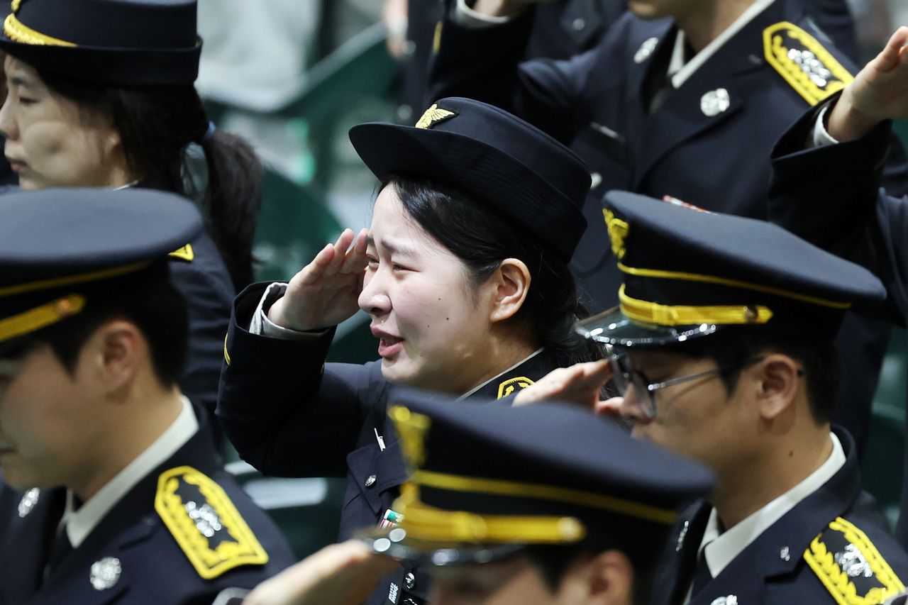 Firefighters salute during a funeral service for the late Senior Fire Lt. Park Seung-won and Fire Sgt. Noh Tae-young at the Wando Agricultural and Fisheries Cultural and Sports Center in South Jeolla Province on Tuesday morning. (Yonhap)