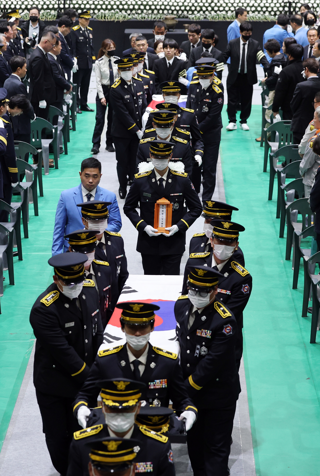 Firefighters carry the coffins during a funeral service for the late Senior Fire Lt. Park Seung-won and Fire Sgt. Noh Tae-young at the Wando Agricultural and Fisheries Cultural and Sports Center in South Jeolla Province on Tuesday morning. (Yonhap)