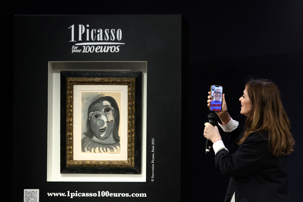 A staff member talks to the winner of the painting "Tete de femme (1941)" by Pablo Picasso, during a charity raffle official draw at Christie's auction house in Paris, Tuesday.    (Reuters-Yonhap)