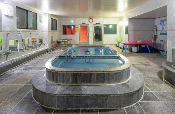 Replica of a traditional Korean public bathhouse mokyoktang showing tiled pools and a steam sauna at the National Folk Museum of Korea