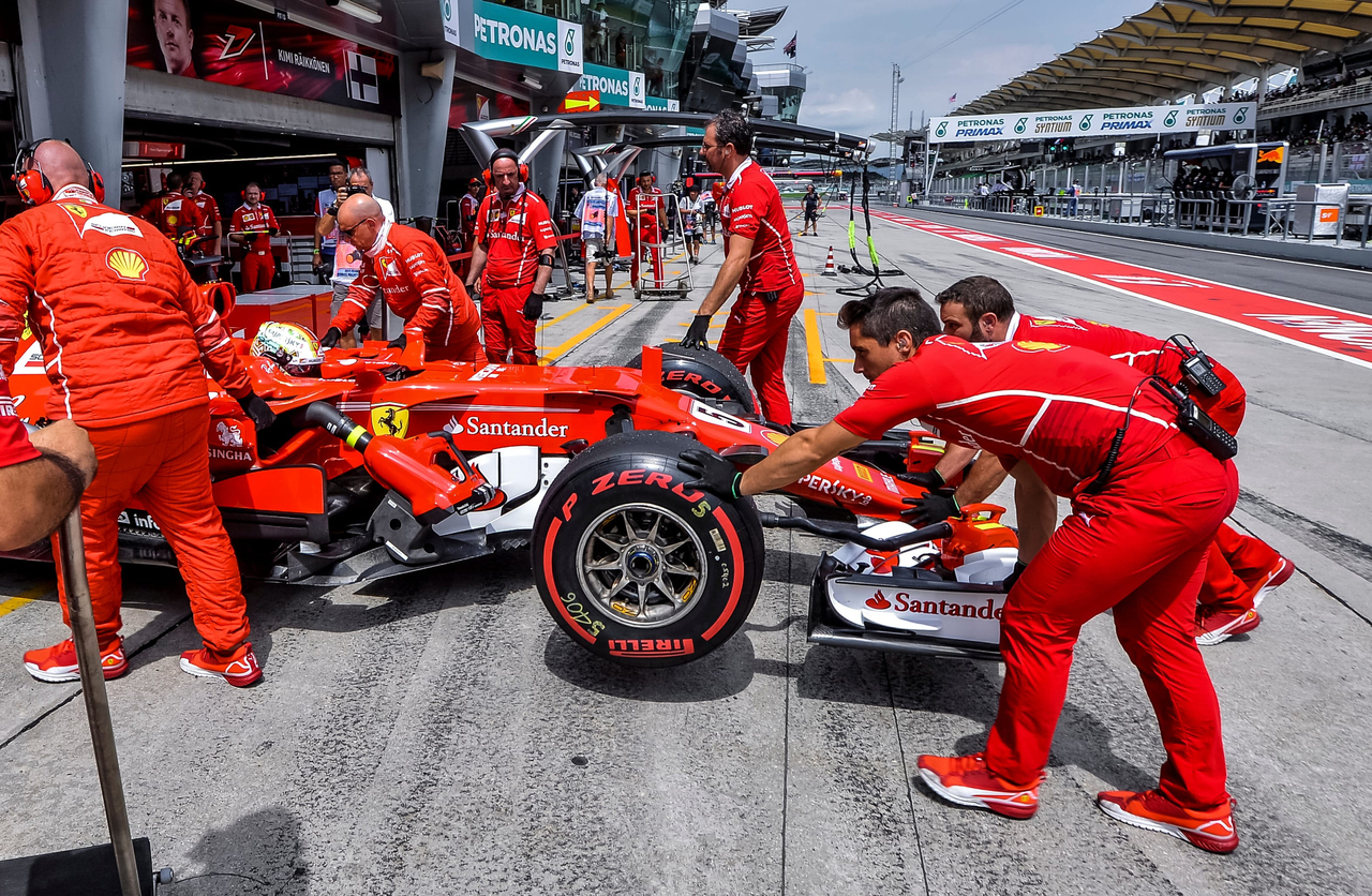 The Scuderia Ferrari team work on the car of Sebastian Vettel in the Pitlane during the Malaysia Formula One (F1) Grand Prix at Sepang International Circuit. (123rf)