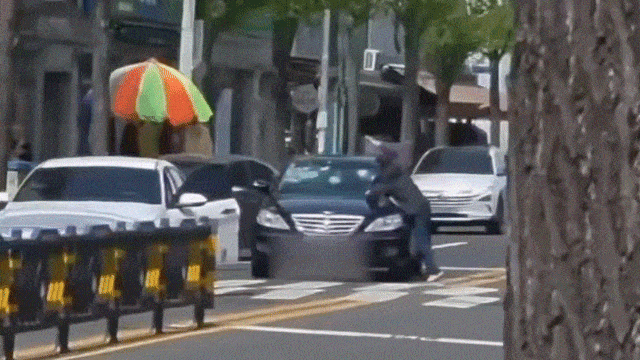 A man smashes a car with a rubber hammer in Ulsan on Wednesday. (Threads @90_doyun)