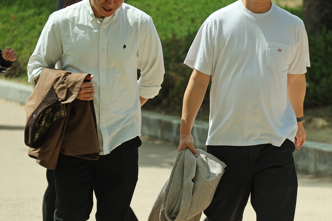 People enjoy a walk in light clothing at Yeouido Park in Seoul on Thursday, as early summer-like weather sets in. Wide temperature swings mean light clothing by day and an extra layer on hand. (Yonhap)