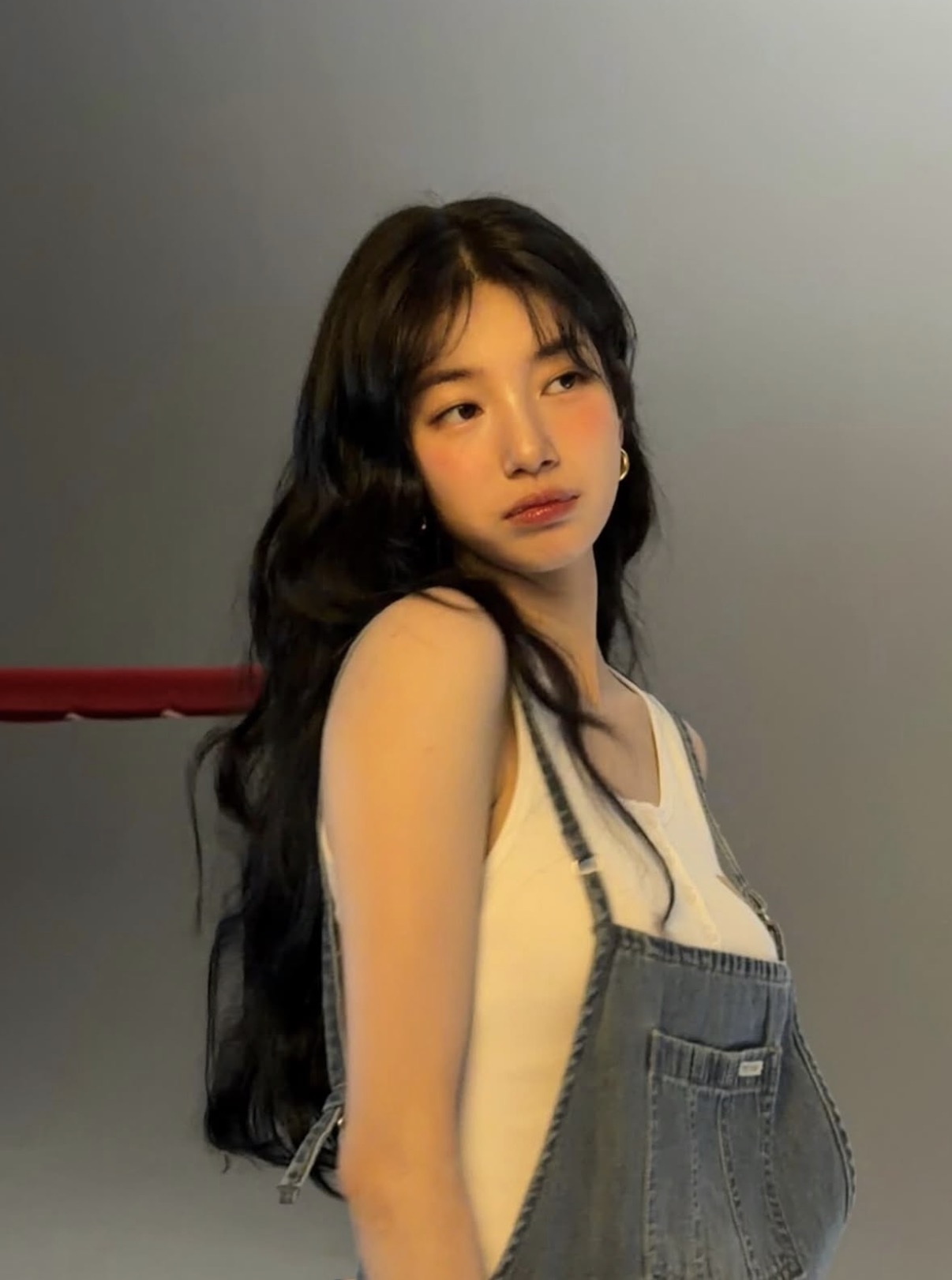 Soft waves and wispy bangs frame the face in a relaxed, romantic look, highlighting the season’s shift toward natural texture and understated styling. (Suzy)