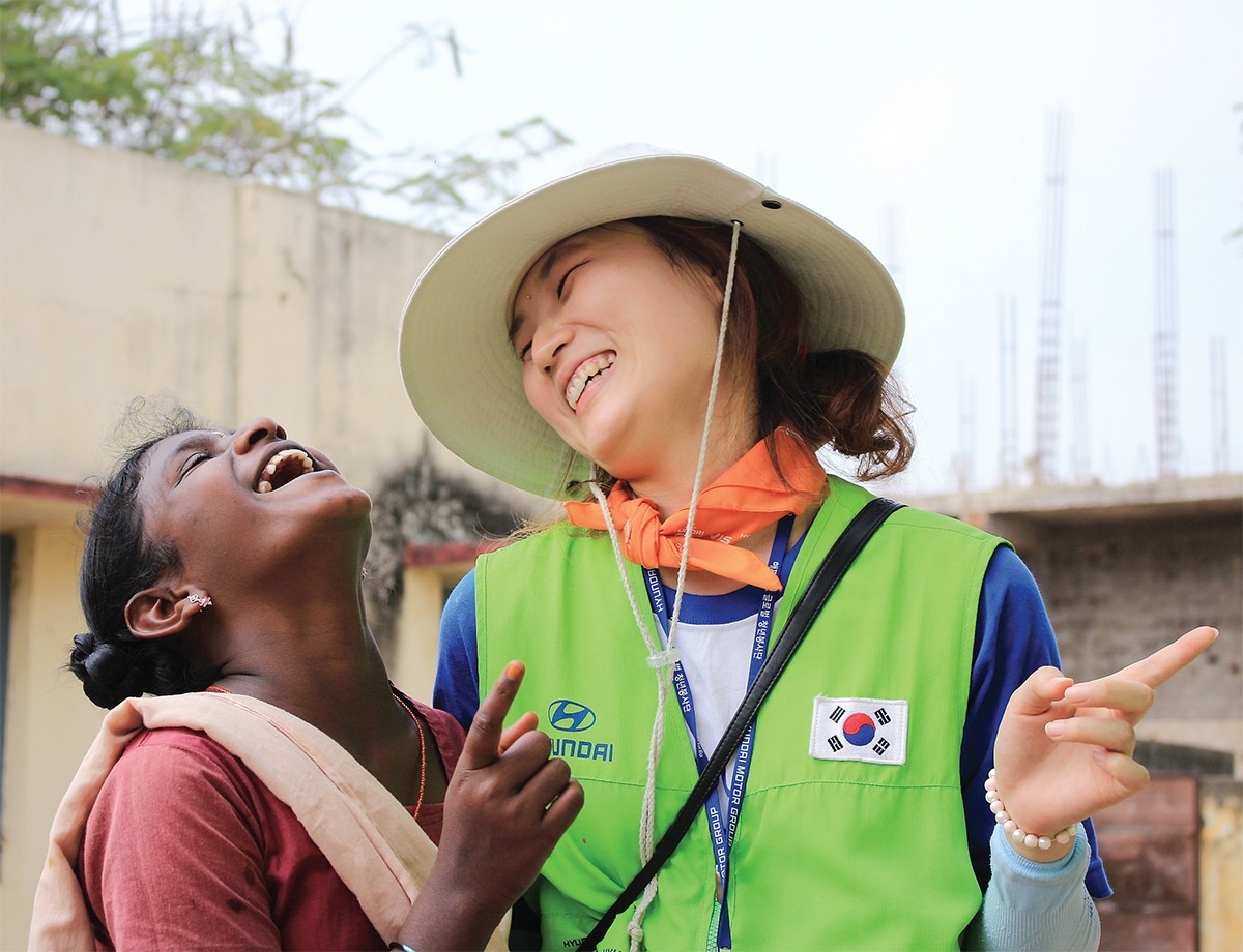 A volunteer with Hyundai Motor Group’s "Happy Move" program shares a smile with a local woman in India. (Hyundai Motor Group)