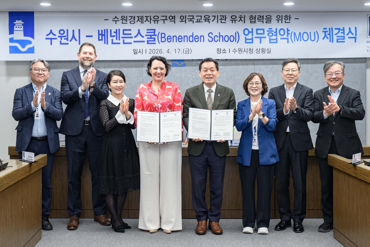 Suwon Mayor Lee Jae-jun (fourth from right) and Benenden School Headmistress Rachel Bailey (fourth from left) pose after signing a memorandum of understanding Friday to explore establishing a branch campus in the city’s planned free economic zone. (Newsis)