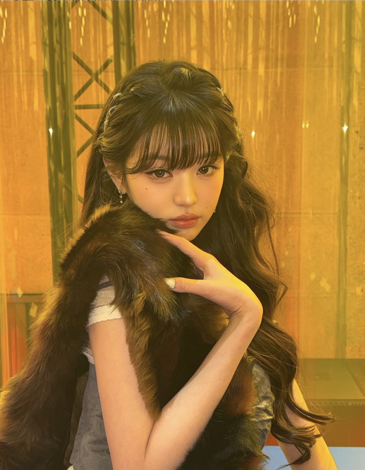 A braided headband wraps around the crown, pairing loose waves that highlight the season’s textured styling. (Jang Wonyoung)