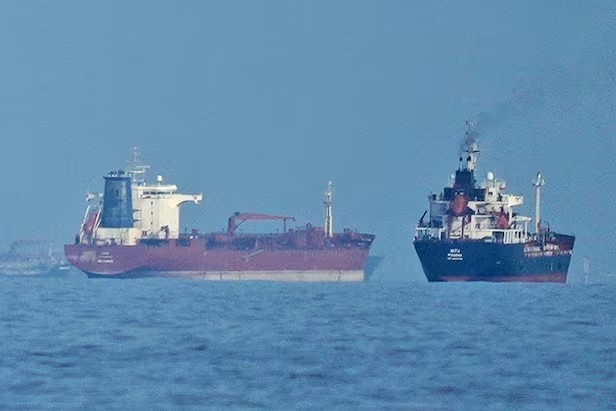 An oil tanker and a cargo ship pass through the Strait of Hormuz. (Reuters-Yonhap)