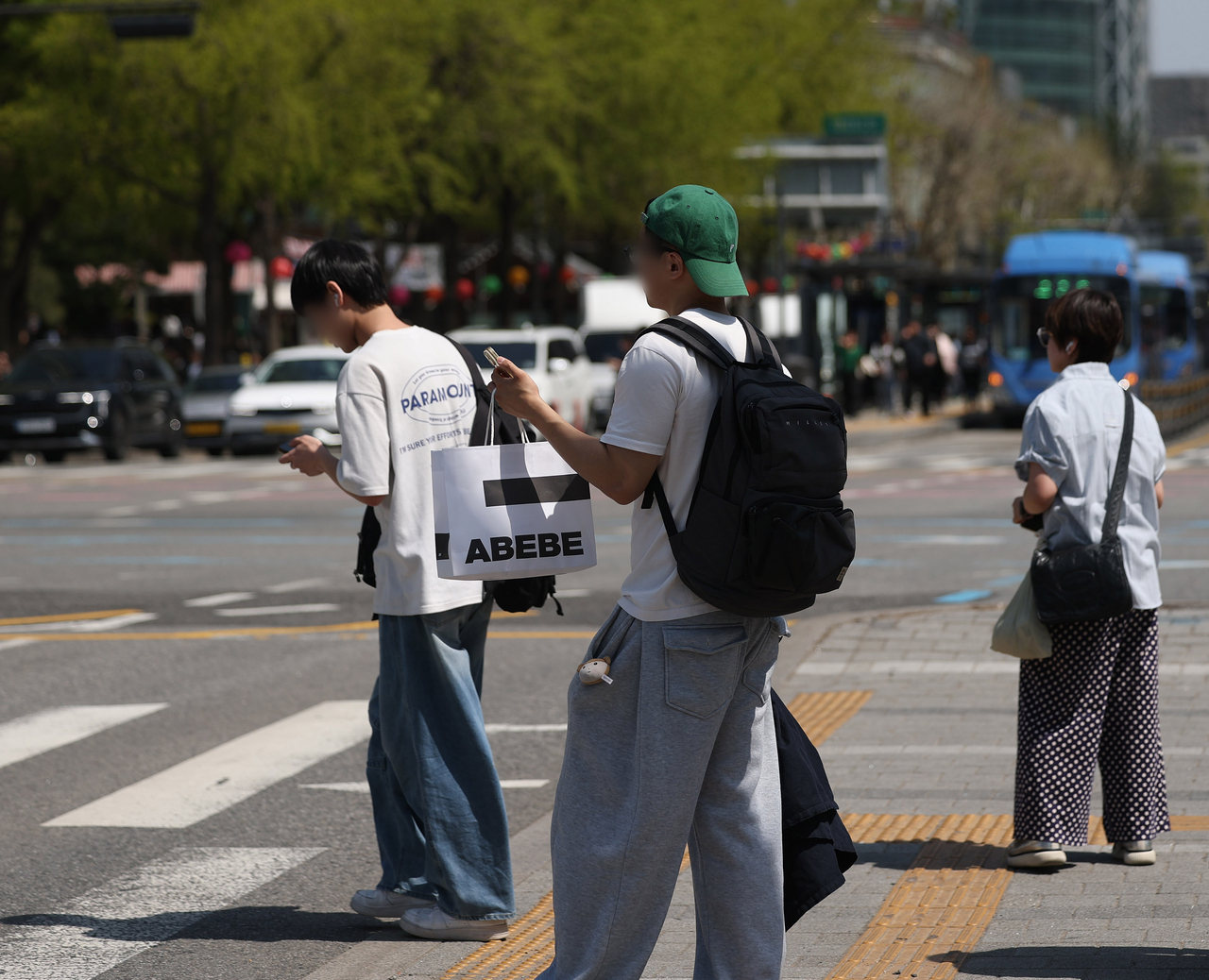People walk along a street in Seoul in short sleeves on Monday as the daytime high rose to 25 degrees Celsius. (Yonhap)