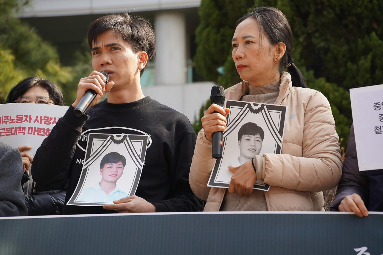 Those gathered for a press conference on March 12 calling for a probe into the death of 23-year-old Vietnamese worker Nguyen Van Tuan hold up pictures of the victim in front of the Gyeonggi Regional Office of Employment and Labor. (Gyeonggi Migrants Equality Solidarity)