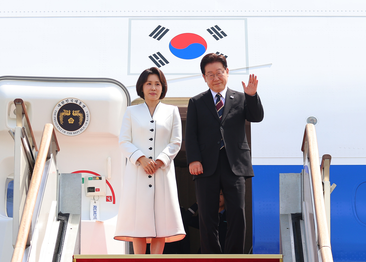 President Lee Jae Myung and first lady Kim Hea Kyung wave before departing from Seoul Air Base in Seongnam, just south of Seoul, on Sunday for Lee’s state visit to India, where he is set to hold a summit with Prime Minister Narendra Modi in New Delhi. (Yonhap)