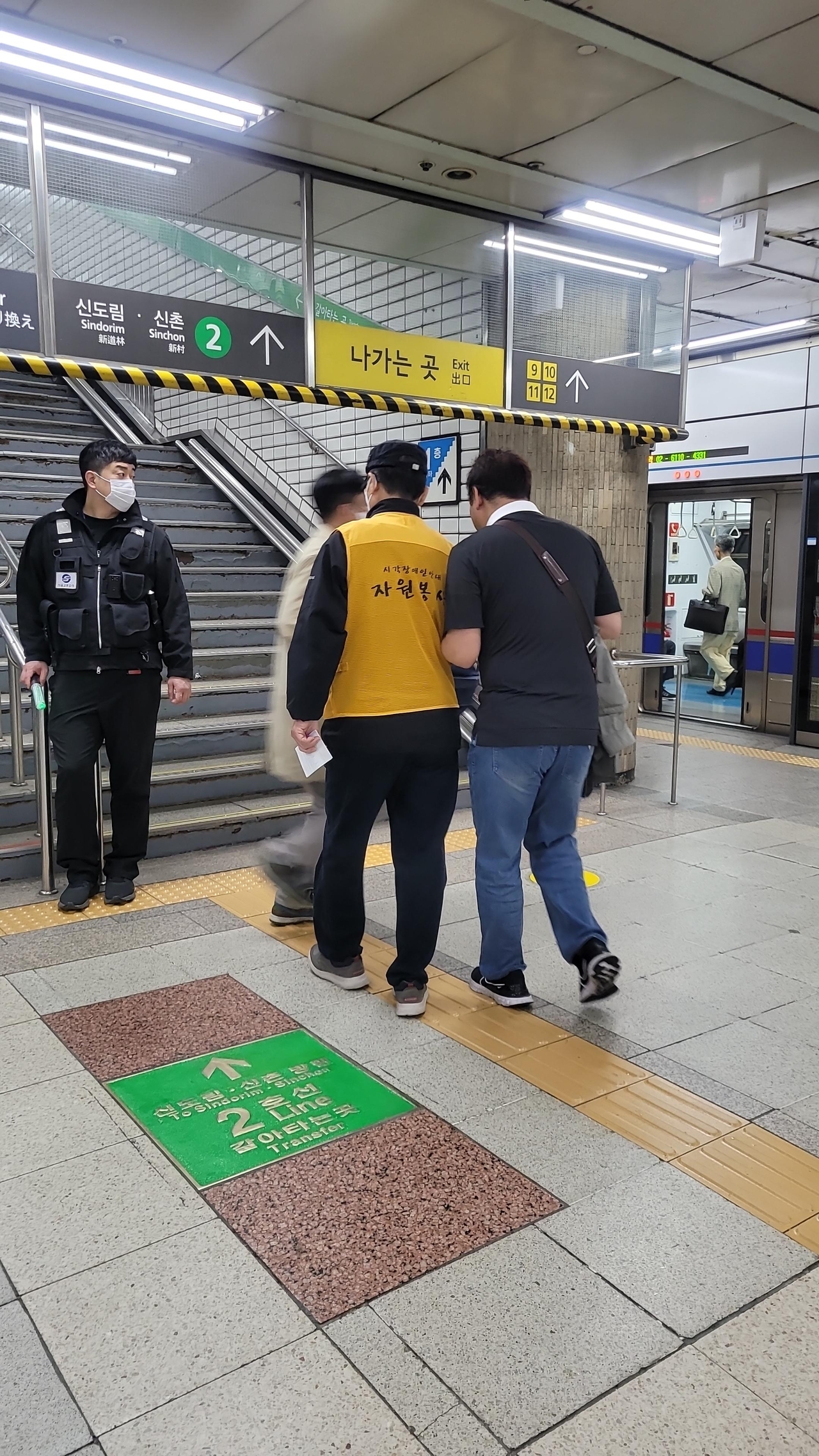 A passenger with low vision is assisted by staff at a subway station. (Seoul Metropolitan Government)