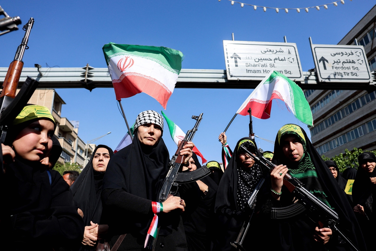 Iranian women brandish their rifles as they take part in a rally in tribute of women killed in the US-Iran war, in Tehran, Friday.   (AFP-Yonhap)