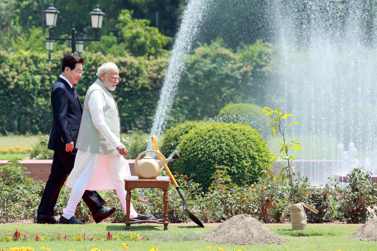 President Lee Jae Myung and Indian Prime Minister Narendra Modi walk to a commemorative tree-planting ceremony at Hyderabad House in New Delhi on Monday. (Yonhap)