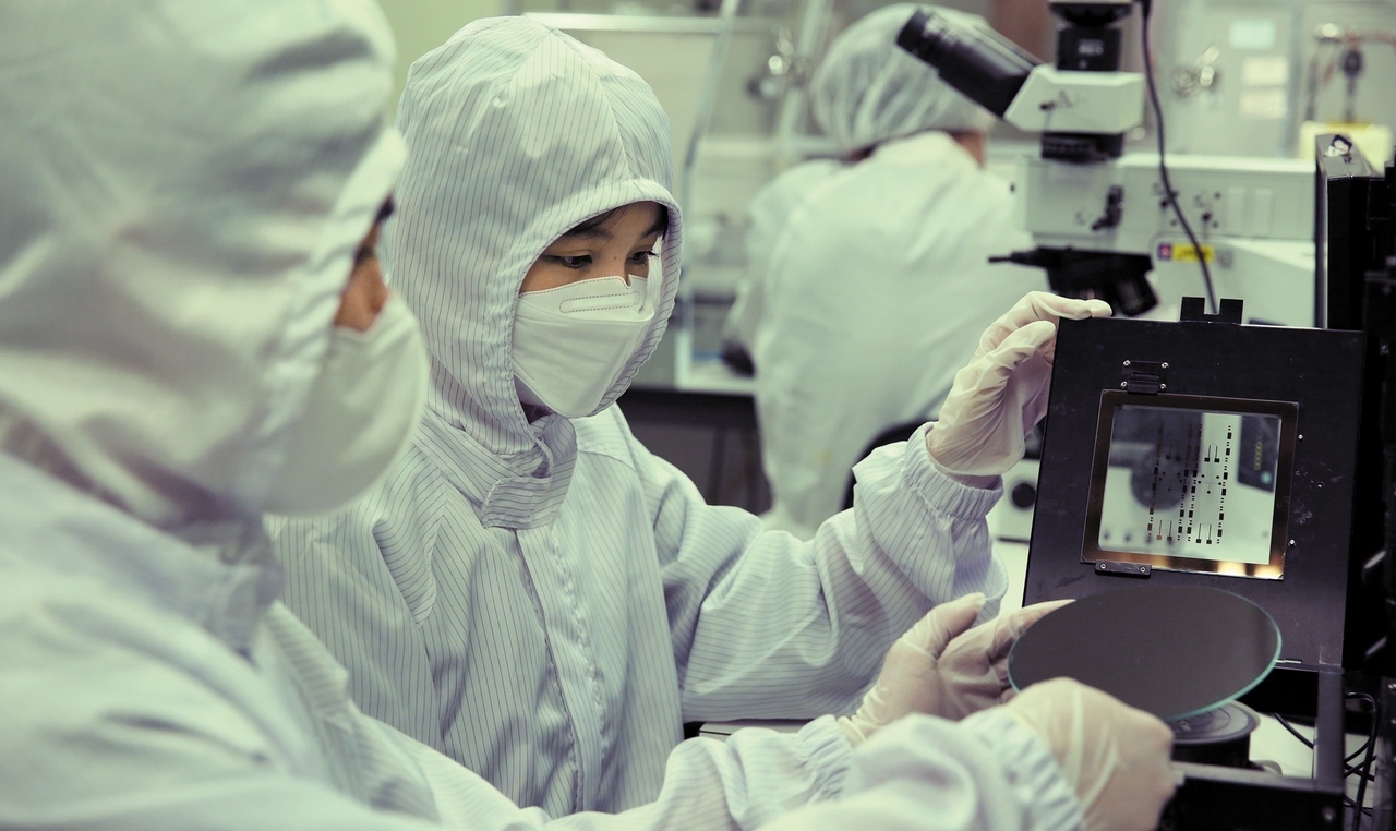 Sogang University students examine a semiconductor wafer as part of hands-on fabrication training with SK hynix offered through the school. (Sogang University)