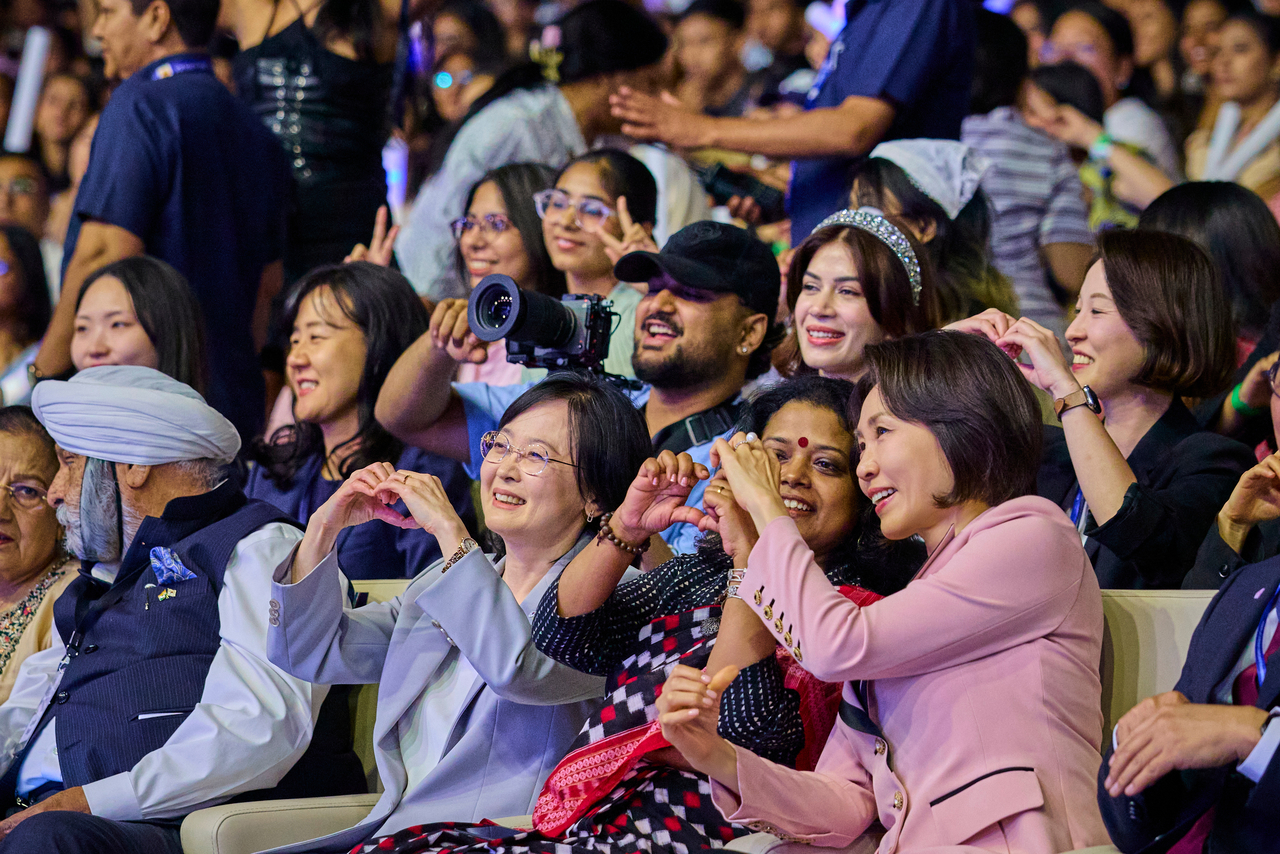 First lady Kim Hea Kyung, who accompanies President Lee Jae Myung on a state visit to India, makes finger-heart gestures with attendees at the K-Dream Stage event at Yashobhoomi convention center in New Delhi on Monday. (Joint Pool Photo via Yonhap)