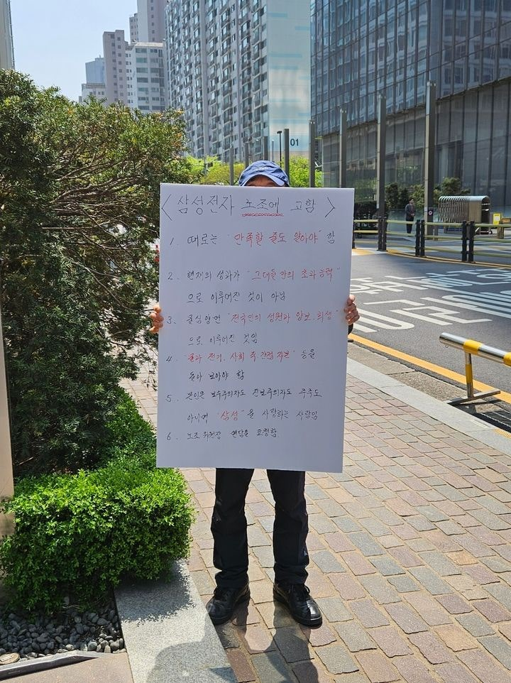 A protester holds a placard criticizing union bonus demands outside Samsung Electronics’s Seocho-gu headquarters in Seoul on April 15, addressing the corporate profit-sharing debate. (Newsis)